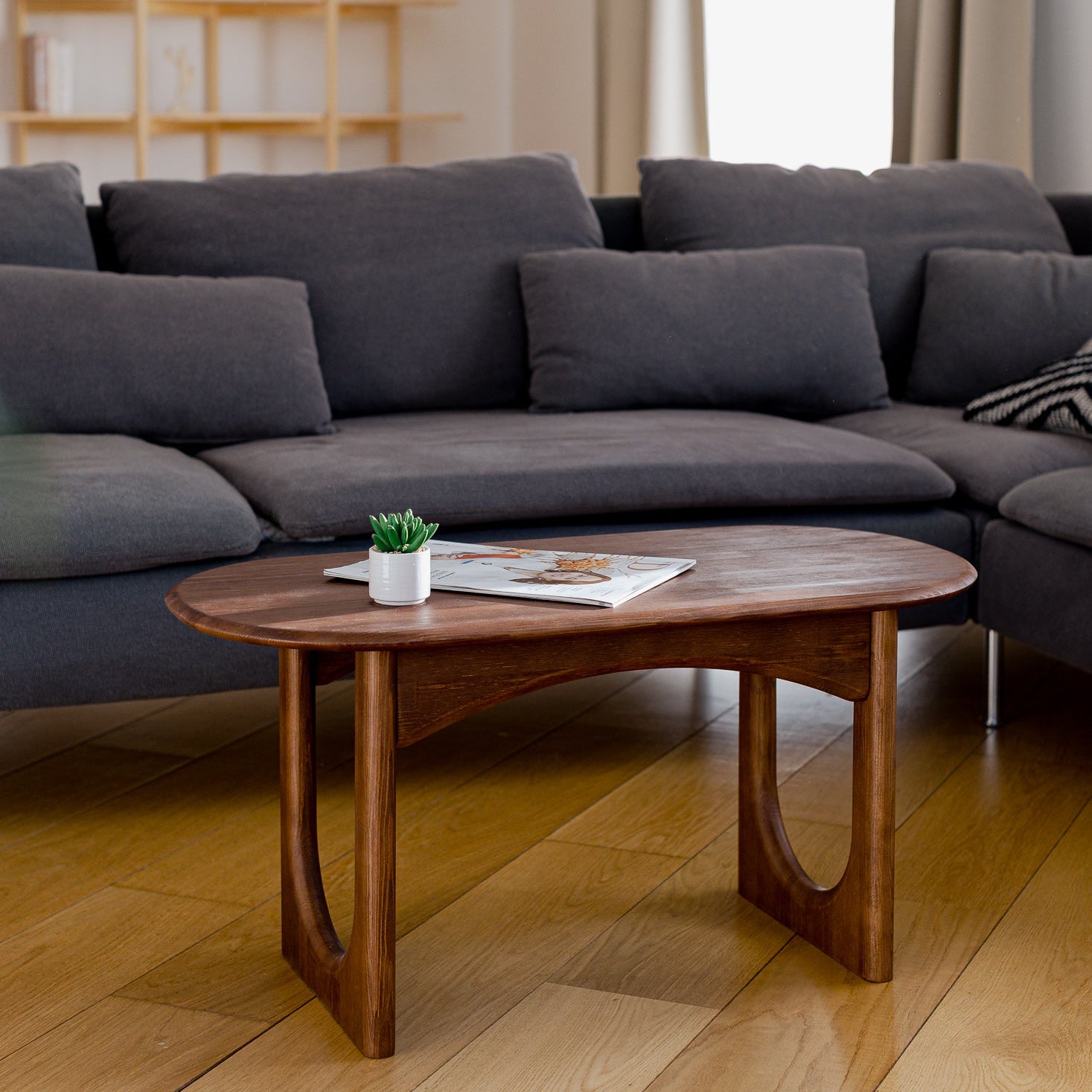Living room with a dark gray sectional sofa and wooden coffee table.