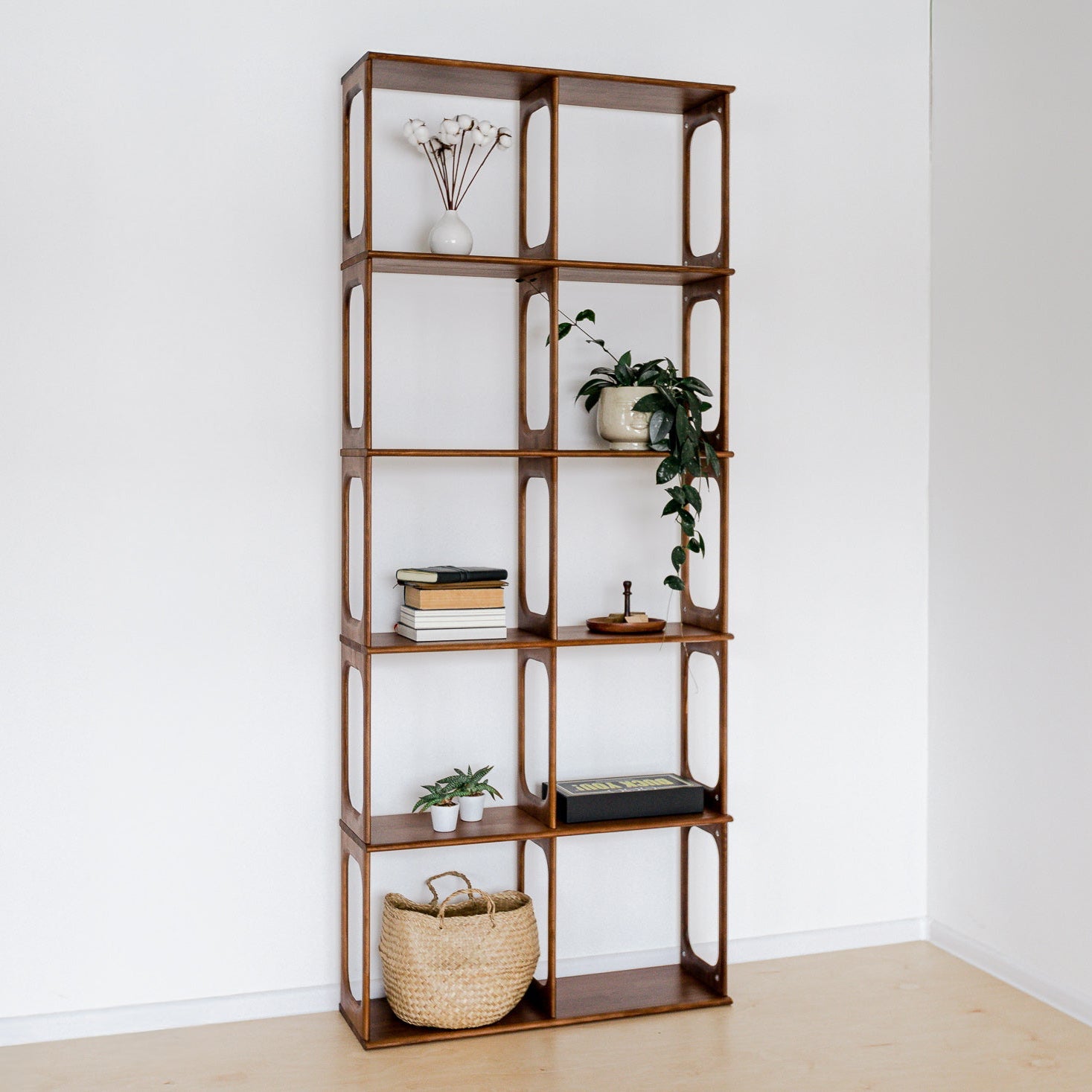 Wooden bookshelf with decorative items against a white wall